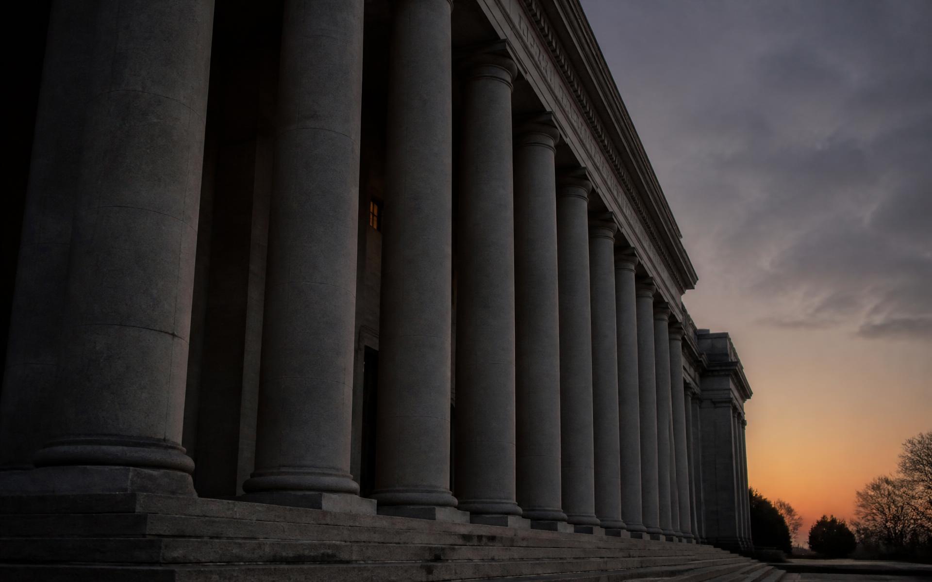 Stone colonnade of an institutional building at dusk