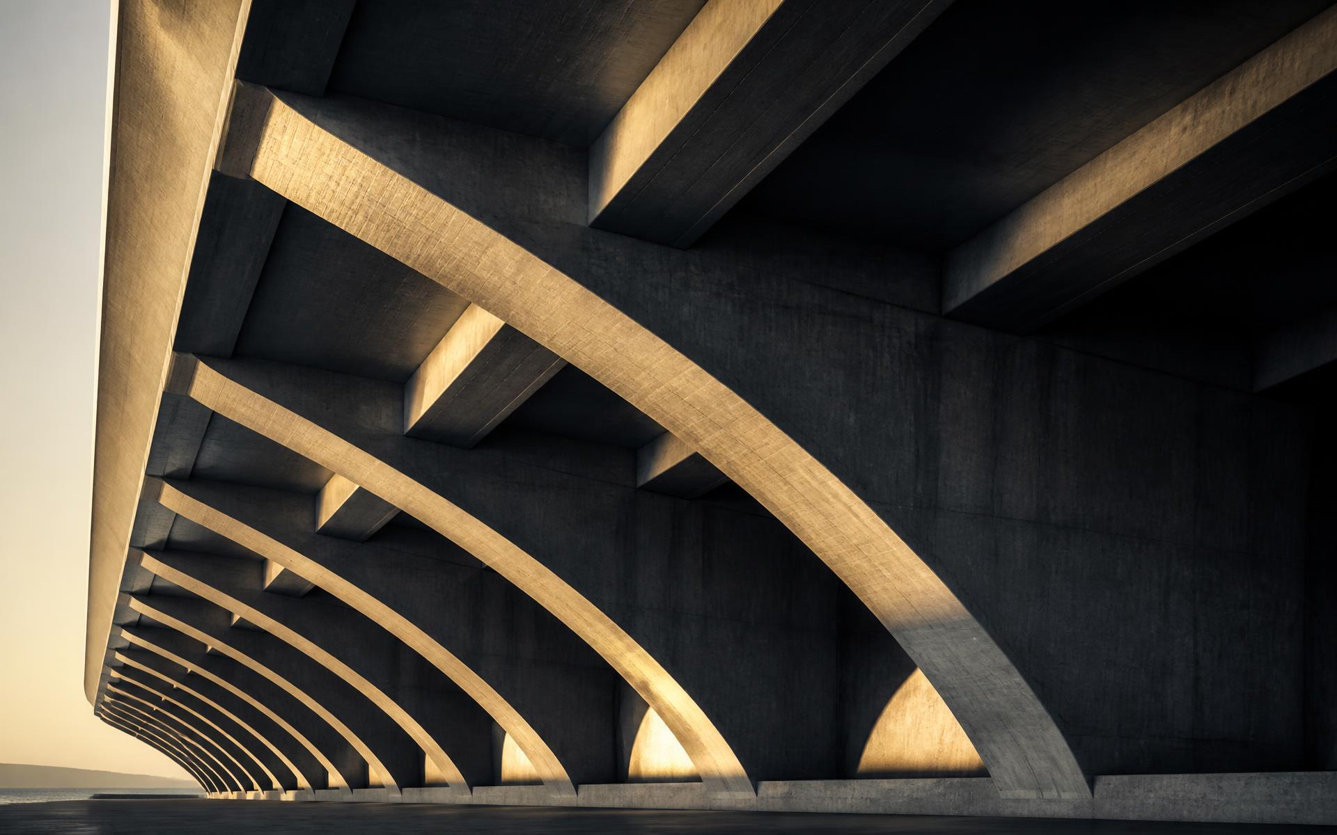 Underside of a concrete bridge, repeating structural ribs in raking light